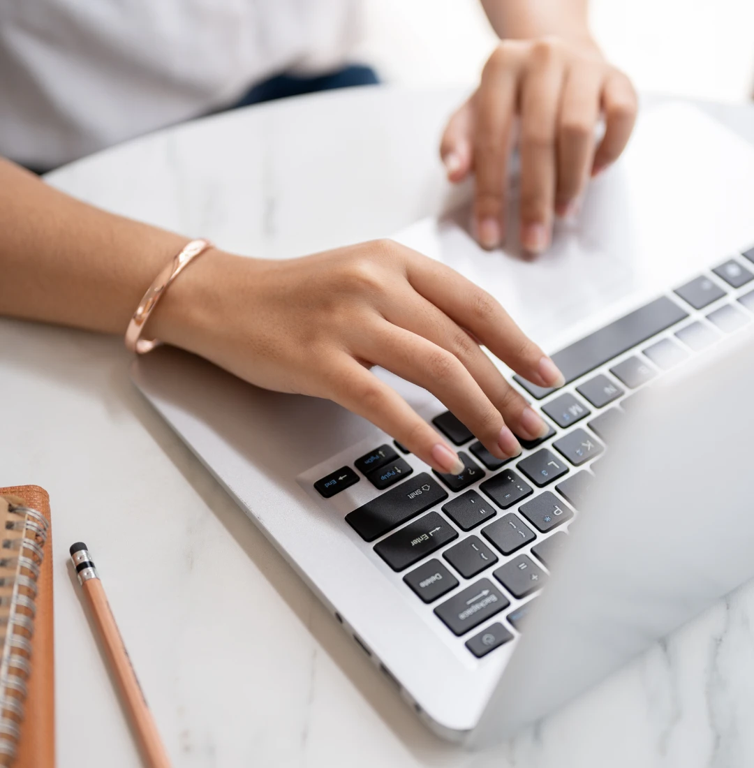 Woman's hands using a laptop keyboard