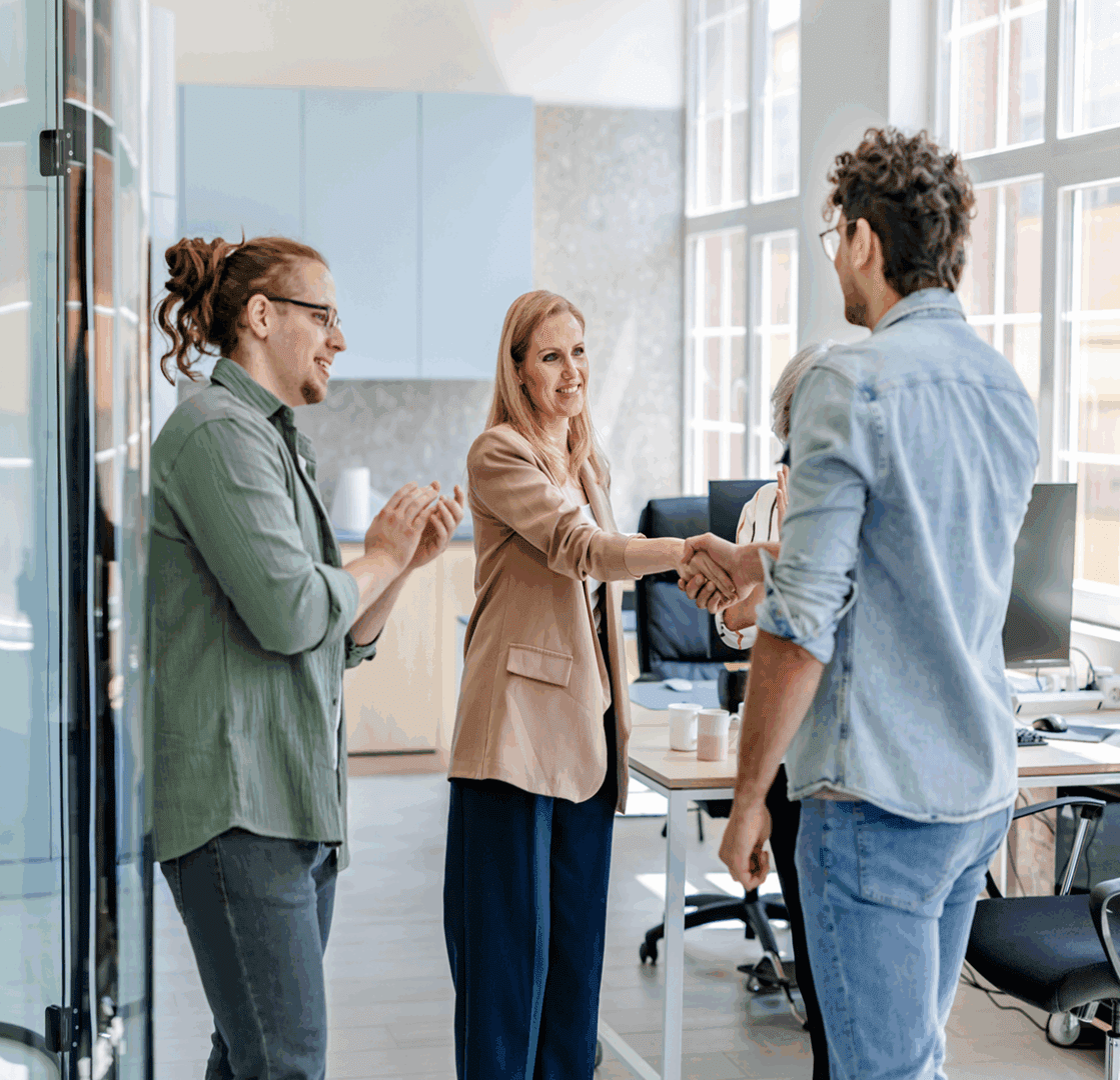 Office team shaking hands and smiling
