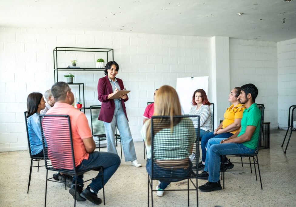 Group discussion with facilitator in bright room.