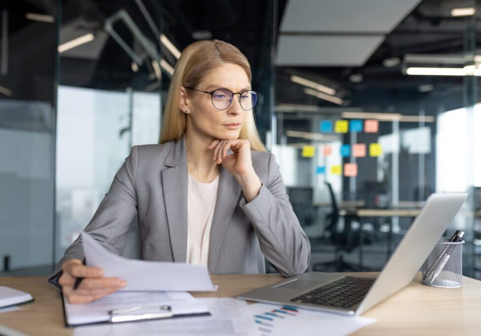Businesswoman working at desk with laptop.